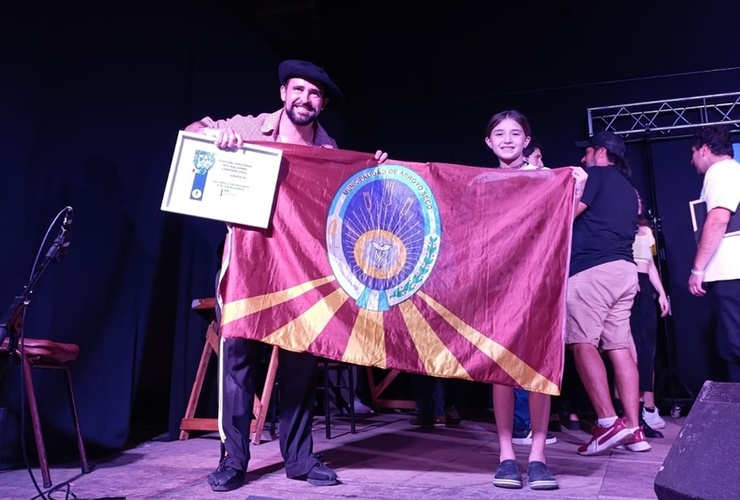 Felicidad a pleno. Maxi junto a su reconocimiento y exhibiendo la bandera de nuestra ciudad.