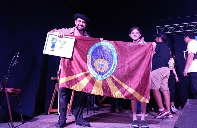 Felicidad a pleno. Maxi junto a su reconocimiento y exhibiendo la bandera de nuestra ciudad.