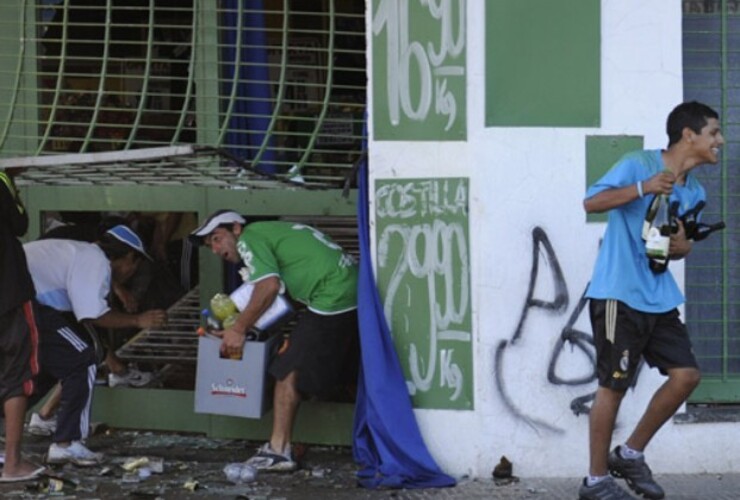 Varios jóvenes se llevan bebidas ayer en uno de los supermercados violentados. (Foto: E. Rodríguez Moreno)