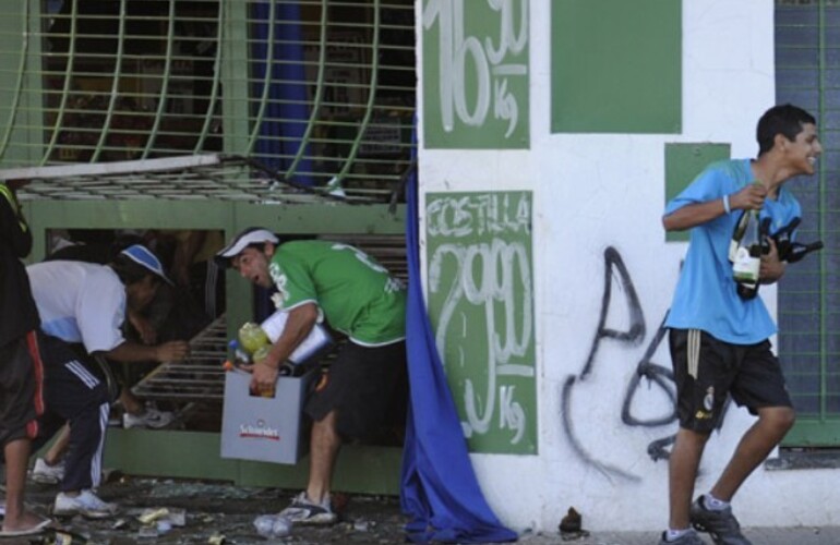 Varios j&oacute;venes se llevan bebidas ayer en uno de los supermercados violentados. (Foto: E. Rodr&iacute;guez Moreno)