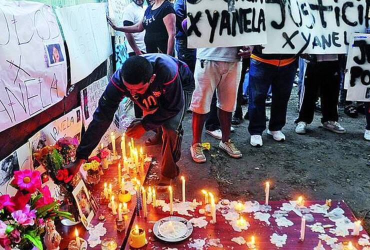 Congoja. Los vecinos de Yanela, ayer, encendiendo velas y poniendo carteles frente a la casa de Berazategui donde vivía la víctima. /FERNANDO DE LA ORDEN