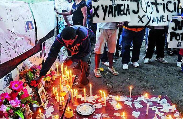 Congoja. Los vecinos de Yanela, ayer, encendiendo velas y poniendo carteles frente a la casa de Berazategui donde vivía la víctima. /FERNANDO DE LA ORDEN