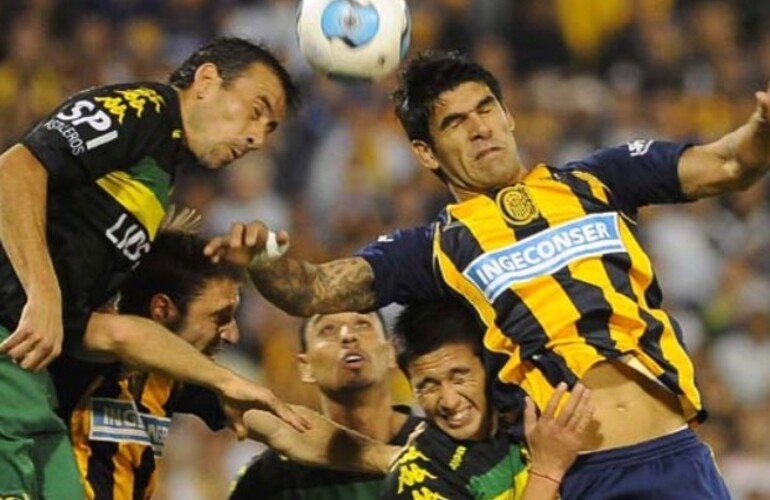 Toledo, que arm&oacute; la jugada del segundo gol canalla, se eleva con un rival.