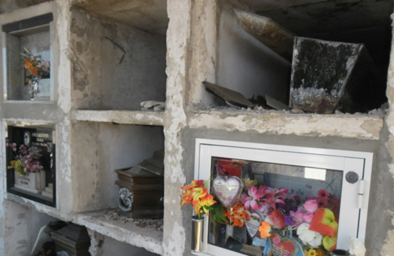 Imagen de Nichos destruidos y ataúdes a la vista en el cementerio