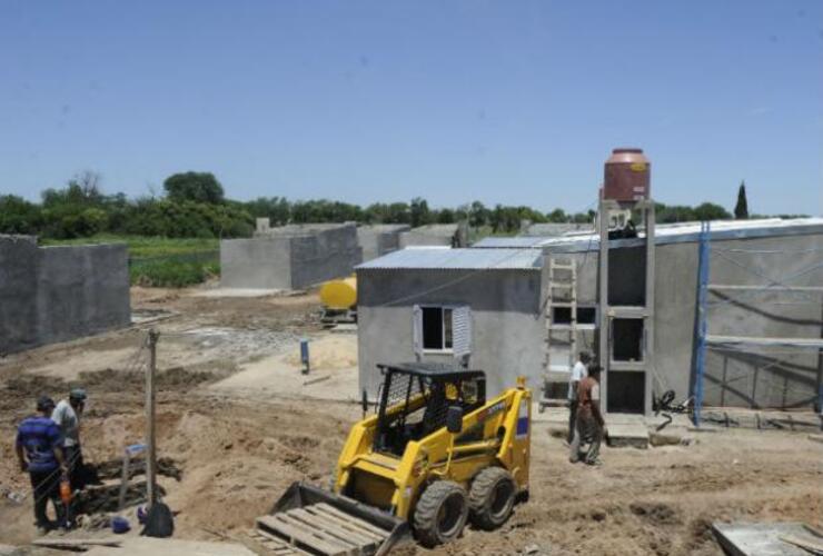 Operarios trabajan en la construcción de las casas donde se mudarán quienes viven a la vera de la ruta.