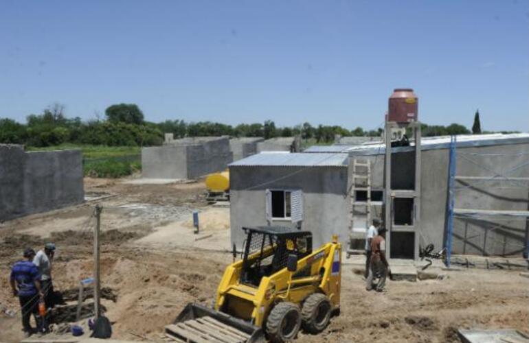 Operarios trabajan en la construcción de las casas donde se mudarán quienes viven a la vera de la ruta.