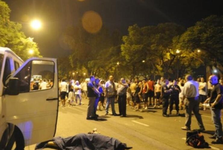 El cuerpo de una de las víctimas junto a la combi momentos después del feroz ataque. Foto: S.Salinas. La Capital