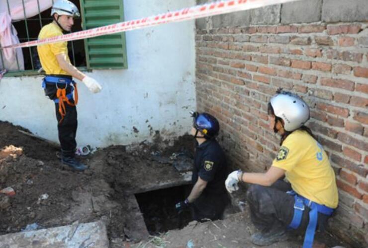 La policía trabajando en el ingreso a uno de los túneles, por el patio de una vivienda.