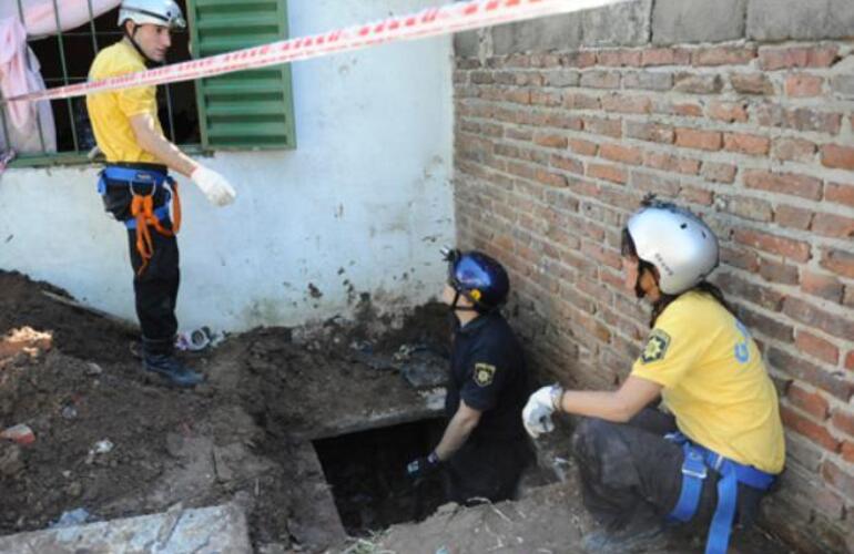 La policía trabajando en el ingreso a uno de los túneles, por el patio de una vivienda.