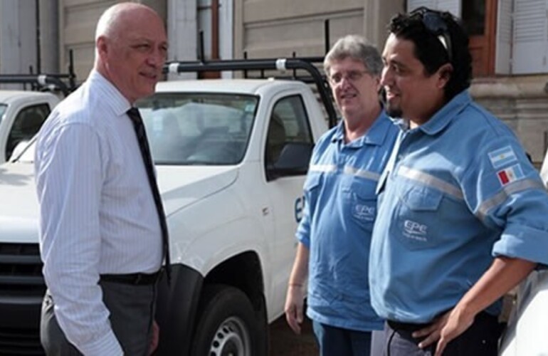 El gobernador dialogando con trabajadores de la EPE durante la entrega de los nuevos vehículos