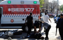 Uno de los ladrones es esposado en la calle estando herido y antes de ser subido a la ambulancia. Foto: Gustavo de los Rios / La Capital