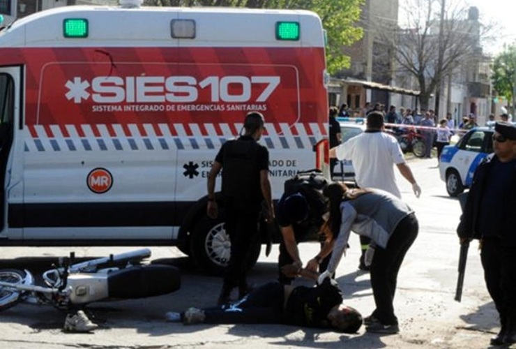 Uno de los ladrones es esposado en la calle estando herido y antes de ser subido a la ambulancia. Foto: Gustavo de los Rios / La Capital