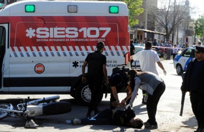 Uno de los ladrones es esposado en la calle estando herido y antes de ser subido a la ambulancia. Foto: Gustavo de los Rios / La Capital