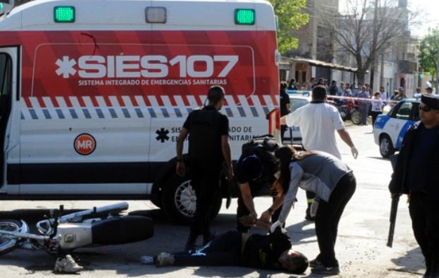 Uno de los ladrones es esposado en la calle estando herido y antes de ser subido a la ambulancia. Foto: Gustavo de los Rios / La Capital