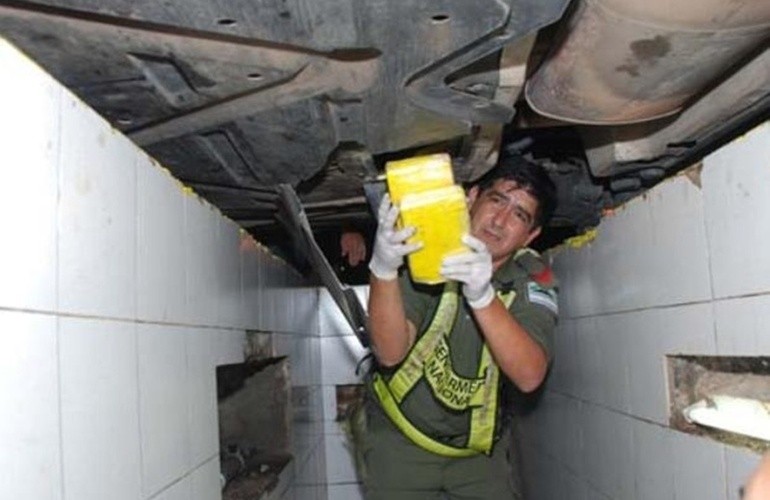 Un gendarme retira los paquetes con droga del chasis de un auto Mercedes Benz que viajaba a Santa Fe. Foto: Clorinda Noticias Un gendarme retira los paquetes con droga del chasis de un auto Mercedes Benz que viajaba a Santa Fe. Foto: Clorinda Noticias
