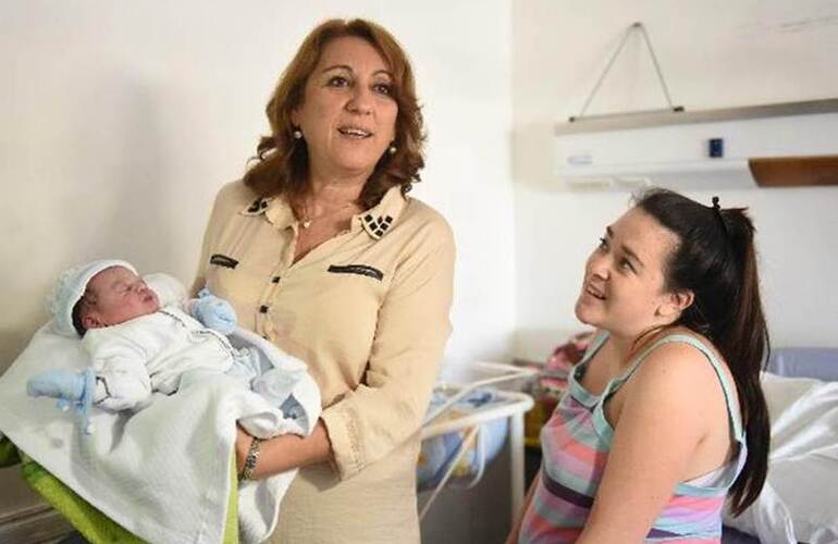 La intendenta Mónica Fein muestra a Dominic, el primer bebé del año en Rosario, mientras mamá Carolina observa la escena. Foto: C. Mutti Lovera