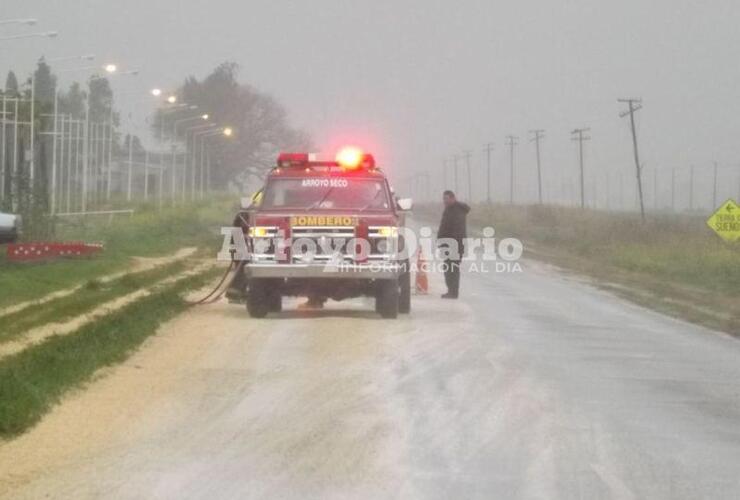 Un móvil con personal. En el lugar trabajaba una dotación de bomberos abocado a sacar el cereal de arriba del pavimento.