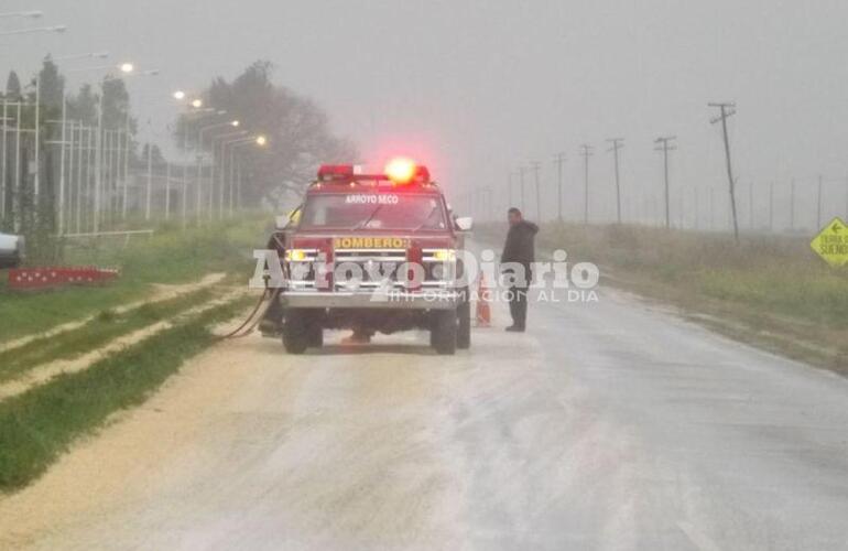 Un móvil con personal. En el lugar trabajaba una dotación de bomberos abocado a sacar el cereal de arriba del pavimento.