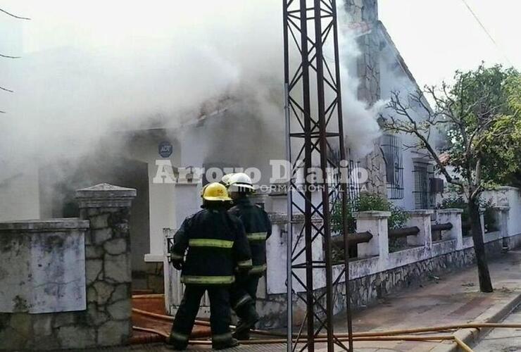 En el lugar. El sub jefe del Cuerpo Activo Matías Massagli (casco blanco) junto al bombero José Luis Ceballos (casco amarillo) ayer trabajando en el incendio.