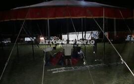 Desarmando la carpa. La gente bajando la estructura del circo acuático.