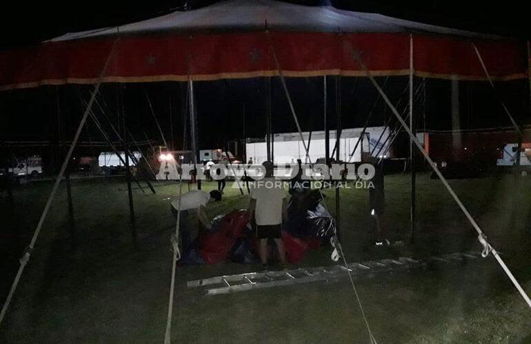 Desarmando la carpa. La gente bajando la estructura del circo acuático.