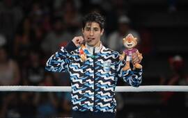 Mirco Cuello muerde su medalla de bronce. Foto: Germán García Adrasti / Clarín