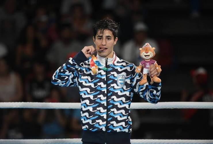 Mirco Cuello muerde su medalla de bronce. Foto: Germán García Adrasti / Clarín