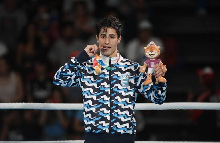 Mirco Cuello muerde su medalla de bronce. Foto: Germán García Adrasti / Clarín