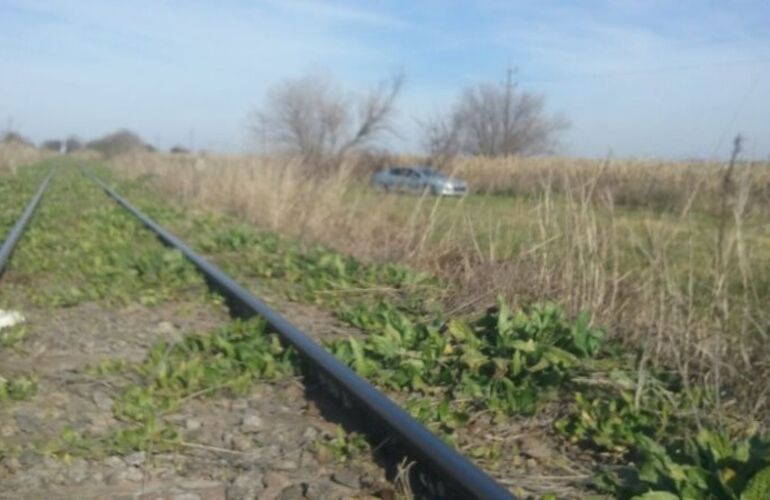 Las vías del ferrocarril al lado del auto que fue saqueado. Foto: Rosario 3