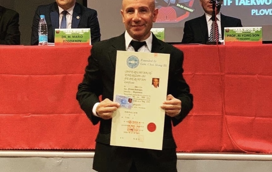 El instructor de Athletic feliz y con su diploma en mano.