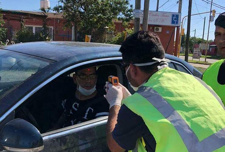 Personal utiliza pistola de calor para detectar la temperatura.