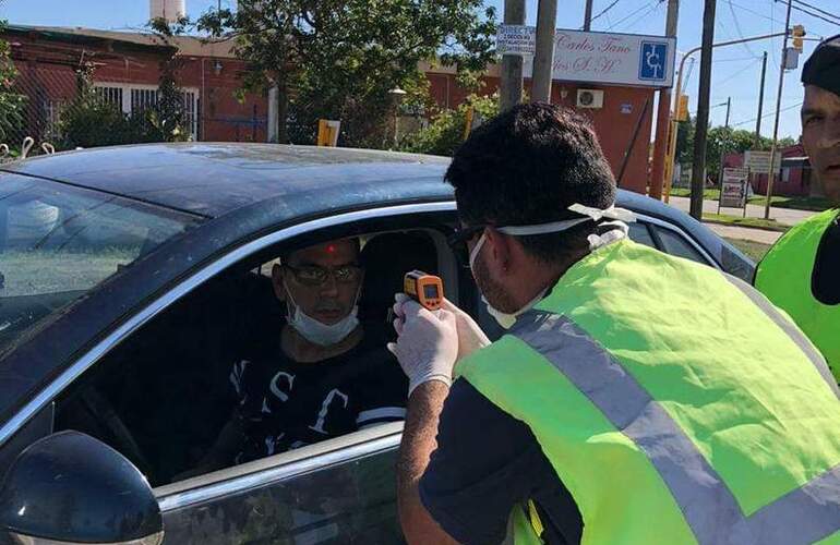 Personal utiliza pistola de calor para detectar la temperatura.