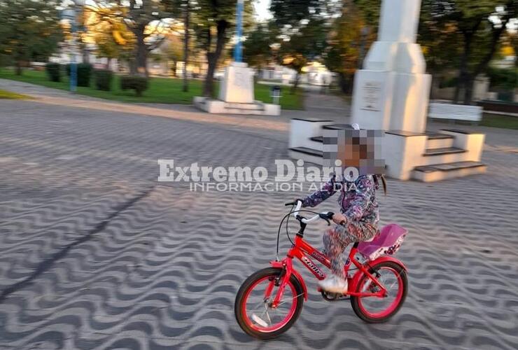 La menor antes de ser embestida por una moto en el medio de la plaza.