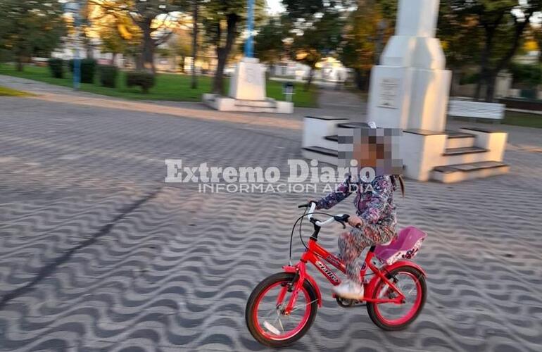 La menor antes de ser embestida por una moto en el medio de la plaza.