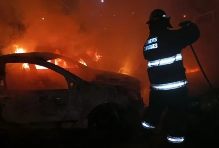 Bomberos Zapadores trabajan sobre uno de los autos incendiados frente a la seccional 32ª.